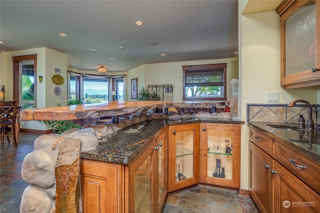 kitchen with a healthy amount of sunlight, tile patterned floors, a breakfast bar, and sink