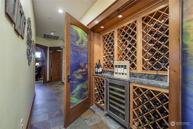 wine area with tile patterned flooring and beverage cooler