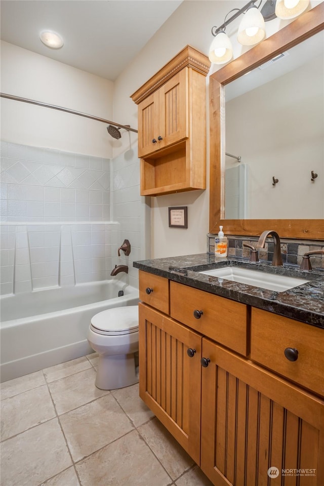 full bathroom featuring tiled shower / bath combo, vanity, tile patterned floors, and toilet