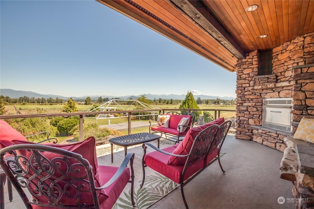 view of patio / terrace with outdoor lounge area, a mountain view, and a rural view