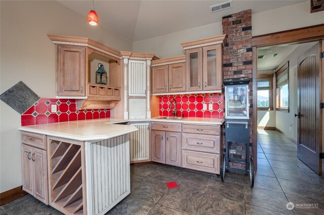 kitchen featuring tasteful backsplash, vaulted ceiling, kitchen peninsula, wall oven, and brick wall