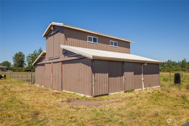 rear view of property with a yard and an outdoor structure