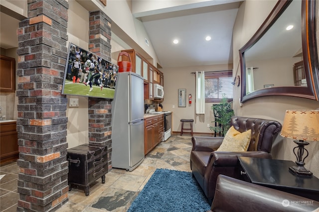 interior space with lofted ceiling, brick wall, and light tile patterned floors