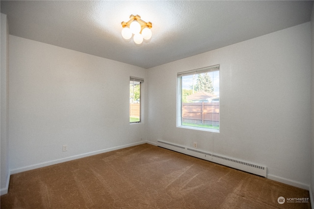 carpeted empty room featuring baseboard heating