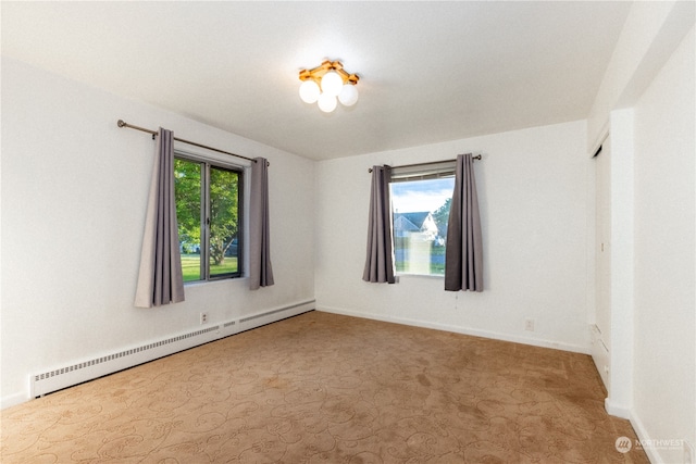 unfurnished room with carpet flooring, a baseboard radiator, and plenty of natural light