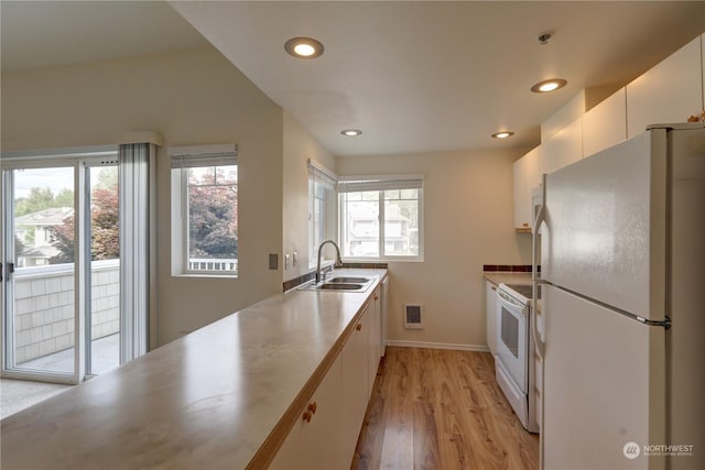 kitchen featuring sink, white appliances, white cabinetry, and light hardwood / wood-style flooring