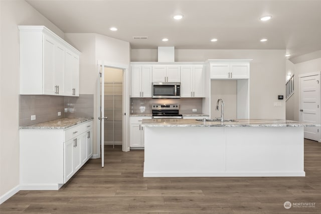 kitchen featuring an island with sink, appliances with stainless steel finishes, sink, and white cabinetry