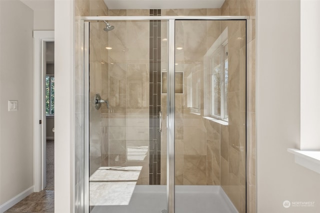 bathroom featuring a shower with door