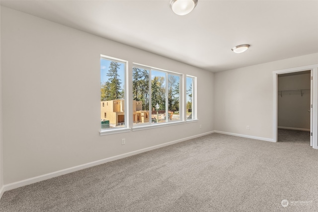 unfurnished bedroom featuring carpet floors, a closet, and a spacious closet