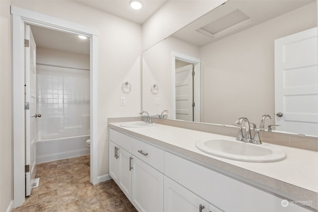 full bathroom with toilet, vanity, and shower / washtub combination