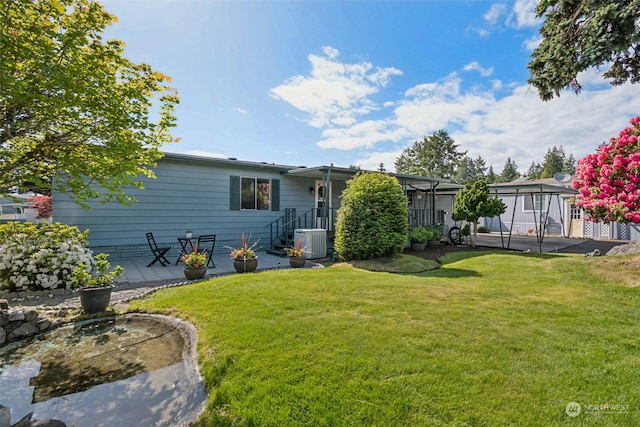 exterior space with cooling unit, a patio, and a lawn