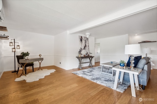 sitting room with hardwood / wood-style floors and a wall mounted AC