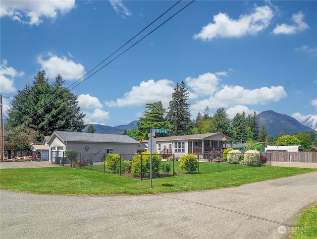 ranch-style home with a garage, a mountain view, and a front lawn