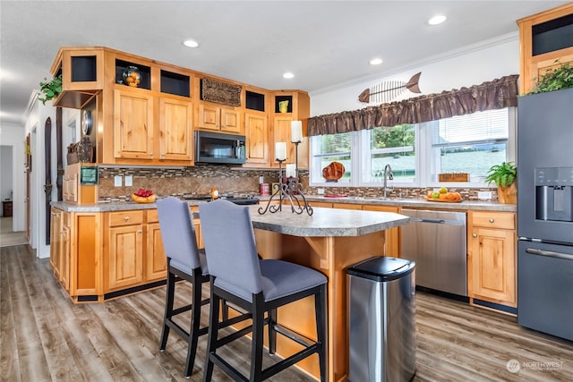 kitchen with light hardwood / wood-style floors, tasteful backsplash, stainless steel appliances, sink, and ornamental molding