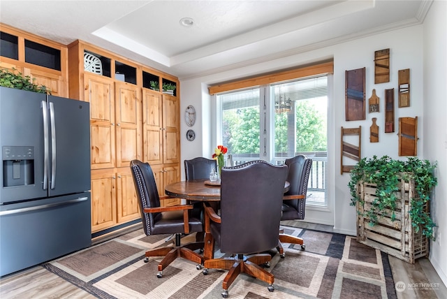 dining area featuring hardwood / wood-style flooring, plenty of natural light, and a raised ceiling