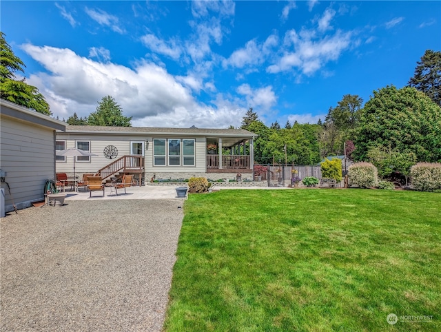 rear view of house with a patio and a lawn