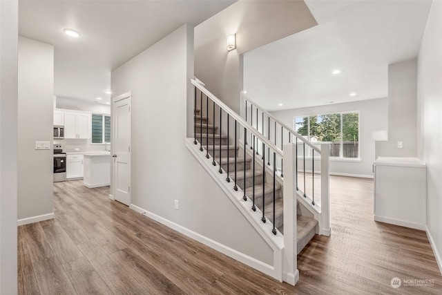 stairs with hardwood / wood-style floors