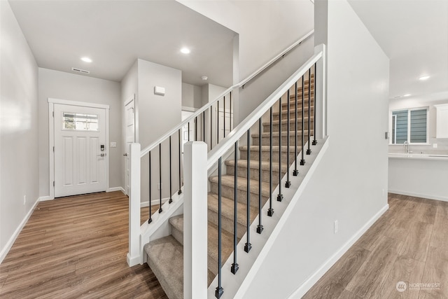 foyer entrance with hardwood / wood-style flooring and sink