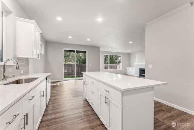 kitchen featuring a kitchen island, dark hardwood / wood-style flooring, sink, and white cabinets