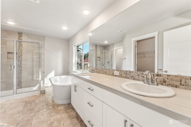 bathroom featuring separate shower and tub, vanity, and backsplash