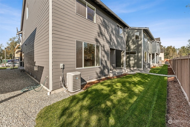 rear view of house featuring a yard and central AC unit