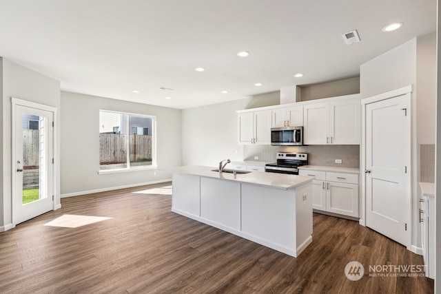 kitchen featuring tasteful backsplash, visible vents, dark wood-style floors, appliances with stainless steel finishes, and a sink