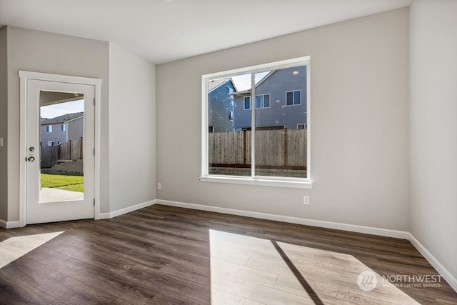 spare room featuring baseboards and wood finished floors