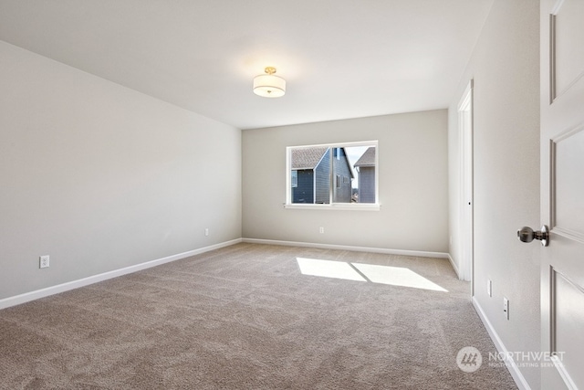 empty room featuring carpet flooring and baseboards