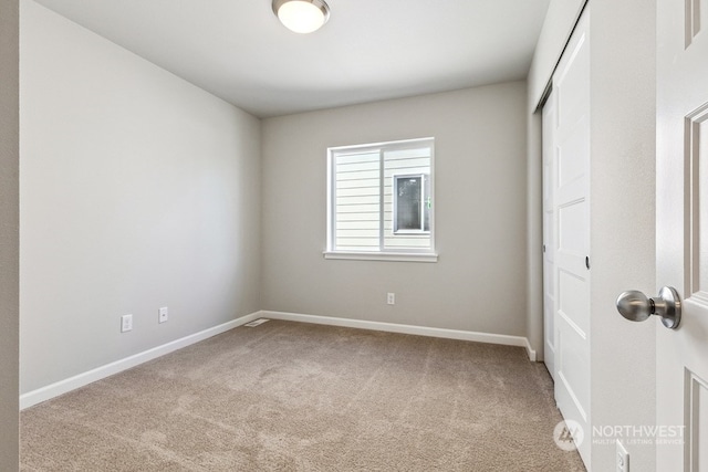 unfurnished bedroom with carpet, a closet, and baseboards