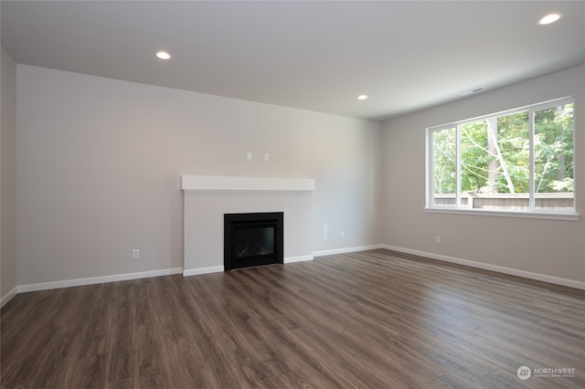 unfurnished living room with dark wood-type flooring