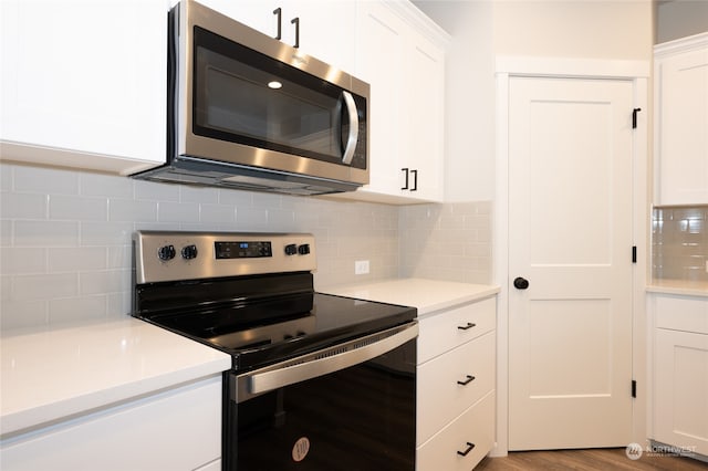 kitchen with appliances with stainless steel finishes, decorative backsplash, light hardwood / wood-style flooring, and white cabinets