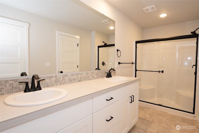 bathroom featuring decorative backsplash, vanity, tile patterned flooring, and a shower with shower door