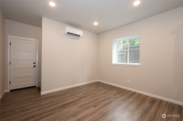 spare room with dark hardwood / wood-style floors and a wall mounted AC