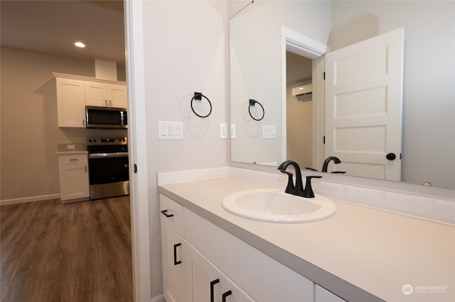 bathroom with wood-type flooring, vanity, and a wall mounted air conditioner