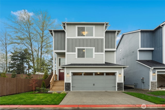 modern home featuring driveway, stone siding, fence, a garage, and board and batten siding