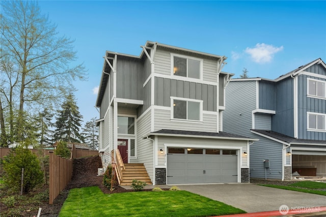 contemporary home with fence, board and batten siding, driveway, stone siding, and a garage