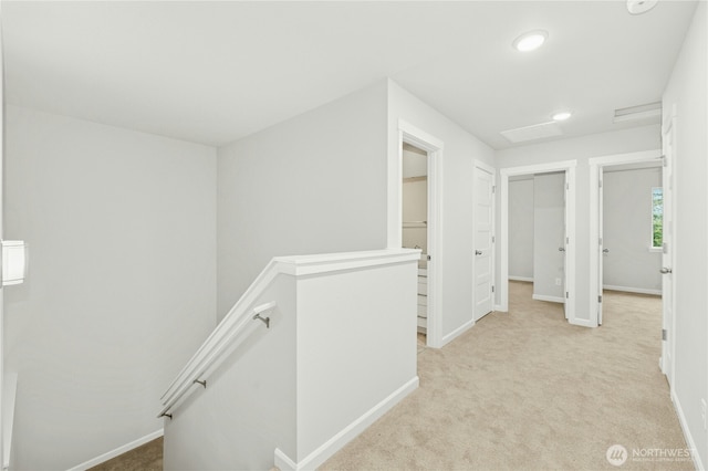 corridor featuring recessed lighting, baseboards, light carpet, and an upstairs landing