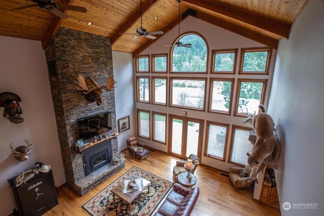 living room with high vaulted ceiling, a healthy amount of sunlight, and light wood-type flooring