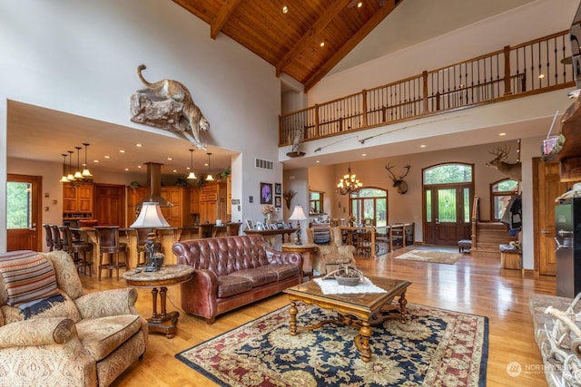 living room featuring plenty of natural light, high vaulted ceiling, wooden ceiling, and light hardwood / wood-style flooring