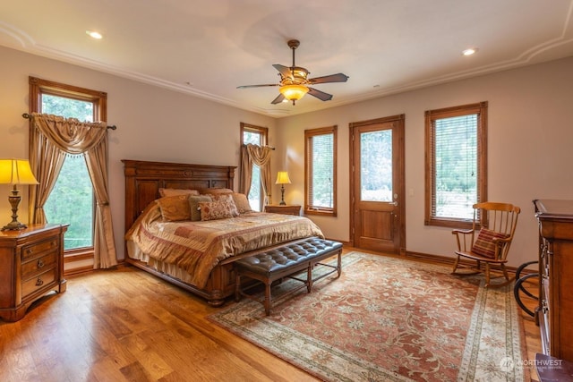 bedroom with multiple windows, ceiling fan, light hardwood / wood-style flooring, and crown molding