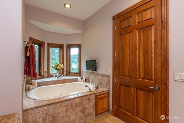 bathroom featuring tile patterned flooring and tiled tub