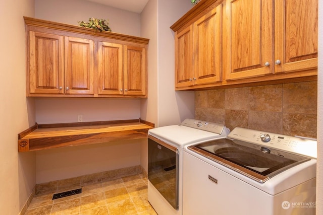 laundry area with washing machine and dryer and cabinets