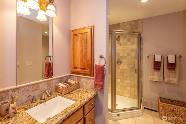 bathroom featuring tile patterned floors, tasteful backsplash, vanity, and walk in shower