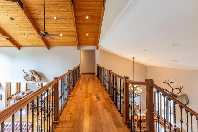 hall with hardwood / wood-style flooring, lofted ceiling with beams, wood ceiling, and a chandelier