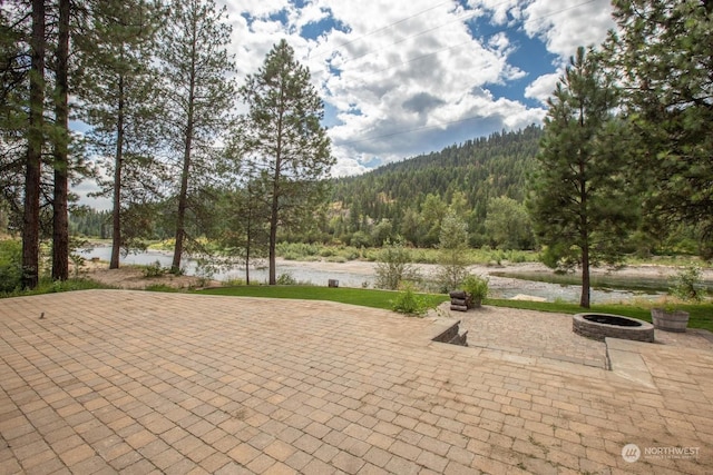 view of home's community featuring a water view, a patio, and a fire pit