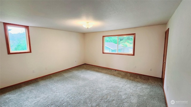 carpeted spare room featuring baseboards