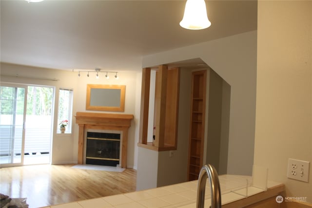 unfurnished dining area featuring track lighting and hardwood / wood-style flooring