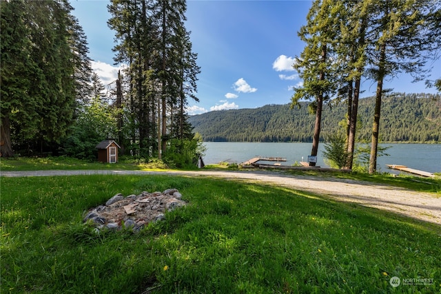 property view of water with a mountain view and a dock