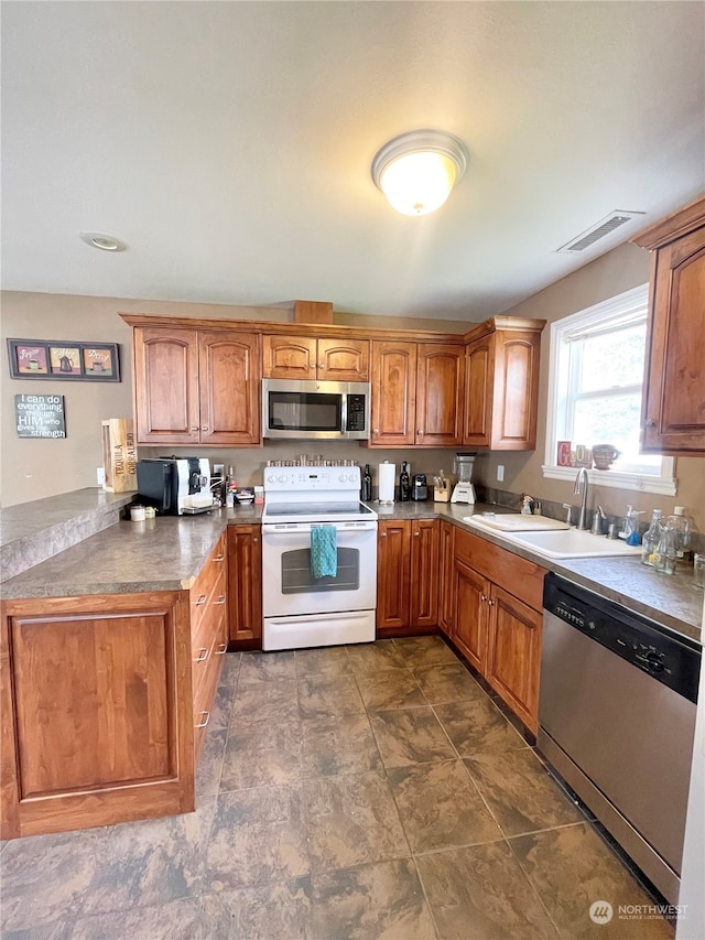 kitchen with sink, dark tile floors, and appliances with stainless steel finishes