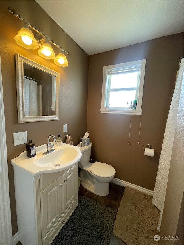 bathroom with tile floors, vanity, and toilet